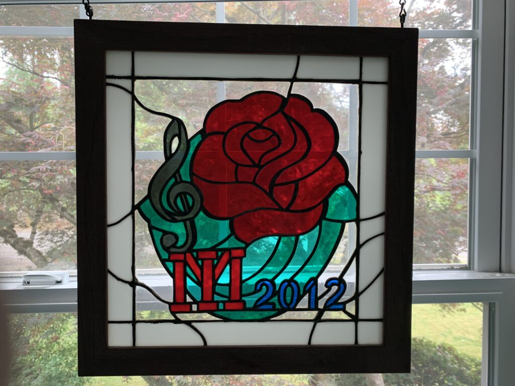 Stained glass image of a Rose, and MI logo